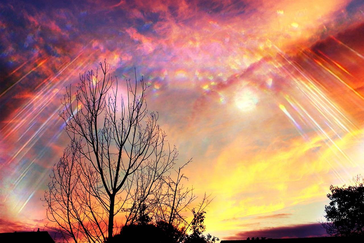 A colorful sky with sun shining through the clouds.